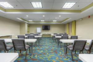 una sala de conferencias con mesas, sillas y una pantalla en Candlewood Suites - Mooresville Lake Norman, an IHG Hotel en Mooresville