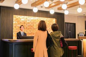 Dwie kobiety patrzące na mężczyznę w barze. w obiekcie The Celecton Matsumoto w mieście Matsumoto