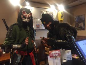 two people dressed in costumes standing in a room at Guest house daisho oshiro asobi in Matsue