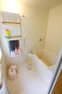 La petite salle de bains est pourvue d'une baignoire et d'un lavabo. dans l'établissement Villa Komakusa, à Hakuba