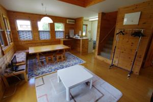 a living room with a table and a bench at Villa Komakusa in Hakuba