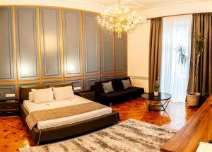 1 dormitorio con cama, sofá y lámpara de araña en Matei Corvin Apartment, en Cluj-Napoca