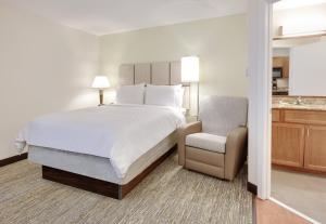 a bedroom with a large bed and a chair at Candlewood Suites Salina by IHG in Salina +18 photos