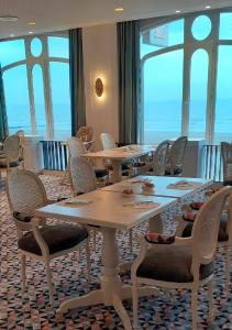 une salle de conférence avec des tables, des chaises et des fenêtres dans l'établissement Hotel Beach Palace, à Blankenberge