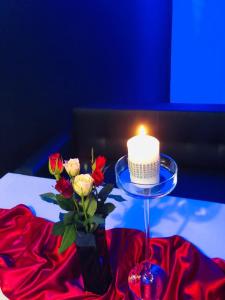 uma vela e um vaso com flores sobre uma mesa em Motel-Restauracja Ballaton em Chustki