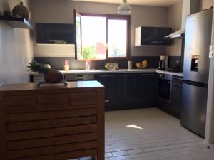 a kitchen with black cabinets and a window at CASE BEAOEL in Saint-Gilles les Bains
