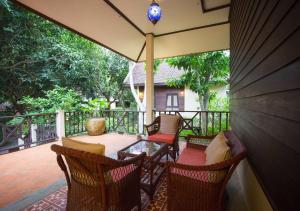 een patio met een tafel en stoelen op een veranda bij Phuwanalee Resort in Mu Si