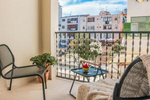 a balcony with a table and chairs and a view of a city at The Boc Suites in Palma de Mallorca