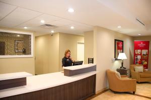 a woman standing at a counter in a waiting room at Candlewood Suites York, an IHG Hotel in York