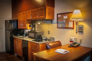 a kitchen with wooden cabinets and a table with a lamp at Candlewood Suites New Iberia by IHG in New Iberia