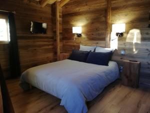 a bedroom with a bed in a log cabin at Chambres et Tables d'Hôtes Le Choton à Nono - Col du Joly Beaufortain in Hauteluce