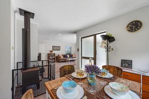 a dining room with a table and chairs at Bach Relax - Mt Maunganui Holiday Home in Mount Maunganui