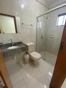 a bathroom with a toilet and a shower and a sink at HOTEL GUAIRACÁ in Guarapuava