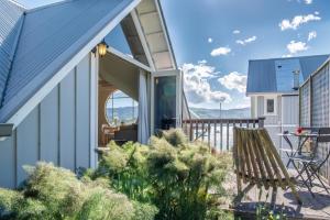 a house with a large sliding glass door on a balcony at The Boathouse - Akaroa Holiday Home in Akaroa