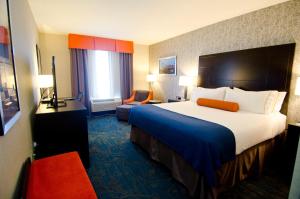 um quarto de hotel com uma cama grande e uma cadeira em Holiday Inn Express Hotel & Suites Knoxville, an IHG Hotel em Knoxville