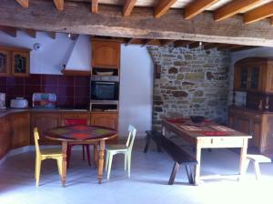 a kitchen with a table and a table and chairs at Au Beau Gîte in Carentoir