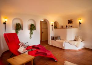 ein Wohnzimmer mit einem roten Stuhl und einem Tisch in der Unterkunft Appart Tramontana in Bürserberg