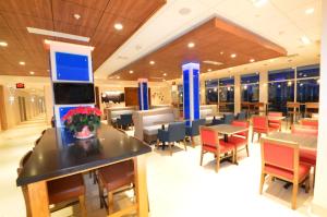 a restaurant with tables and chairs and a lobby at Holiday Inn Express & Suites Toledo West, an IHG Hotel in Toledo