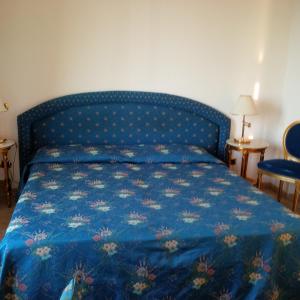 um quarto com uma cama azul e um edredão azul em Hotel Da Vito em Campagna Lupia