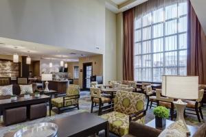 a hotel lobby with tables and chairs and a large window at Staybridge Suites St Louis - Westport, an IHG hotel in Maryland Heights