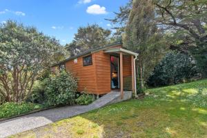 een kleine houten hut in een grasveld bij The Stables Wairoro Park - Russell Holiday Home in Russell