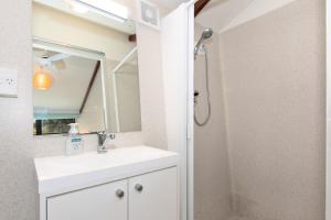 een badkamer met een wastafel en een douche bij The Stables Wairoro Park - Russell Holiday Home in Russell
