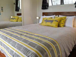 a bedroom with a large bed with yellow and white pillows at Hector's Tiny House - Akaroa Holiday Home in Akaroa