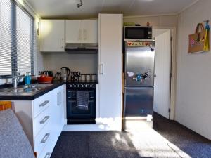 a small kitchen with a refrigerator and a microwave at Hector's Tiny House - Akaroa Holiday Home in Akaroa