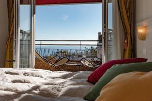 a bed room with a large window overlooking the ocean at Hotel Principe in Sanremo