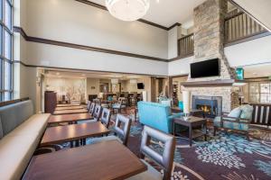 a lobby with tables and chairs and a fireplace at Staybridge Suites Wilmington-Newark, an IHG Hotel in Newark
