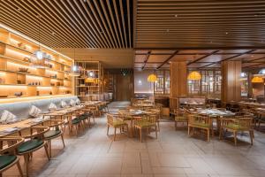 a restaurant with tables and chairs in a room at Holiday Inn Resort Yichun Mingyue Mountain, an IHG Hotel in Yichun