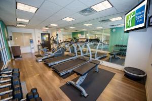 a gym with several treadmills and a television at Holiday Inn Express Tulsa South Bixby, an IHG Hotel in Tulsa
