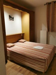 a bedroom with a large bed with a wooden headboard at Appartement Cauterets in Cauterets