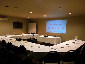 a meeting room with white tables and chairs and a sign at The Park Motel in Hawera