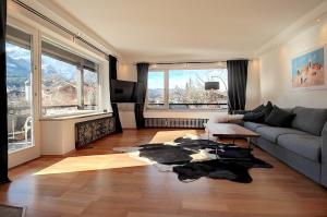 uma sala de estar com um sofá e uma grande janela em Alpenjuwel em Garmisch-Partenkirchen