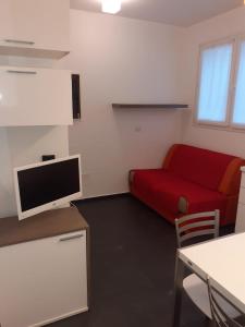 a living room with a red couch and a tv at Residence Villa Gori in Rimini