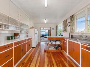 a large kitchen with wooden floors and white appliances at Lofty Lakeviews - Acacia Bay Holiday Home in Taupo