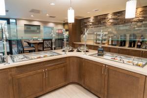a kitchen with wooden cabinets and a dining room at Staybridge Suites Coeur d'Alene, an IHG Hotel in Coeur d'Alene