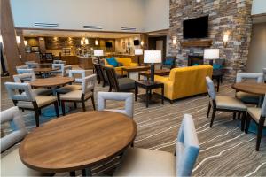a restaurant with tables and chairs and a fireplace at Staybridge Suites Coeur d'Alene, an IHG Hotel in Coeur d'Alene