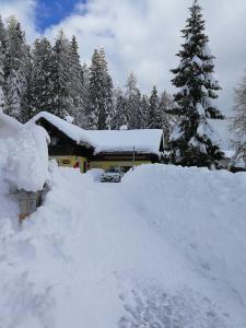 a snow covered house with a pile of snow at Almhütten Sonnblick & Almfried in Sonnenalpe Nassfeld