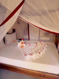 Una cama blanca con un pastel encima. en Uroa Bay Beach Resort, en Uroa