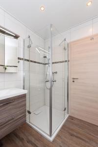 una ducha de cristal en un baño con lavabo en Cliner Nordseehus, en Carolinensiel