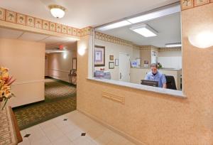 um homem sentado num computador numa sala de espera em Candlewood Suites Tyler, an IHG Hotel em Tyler