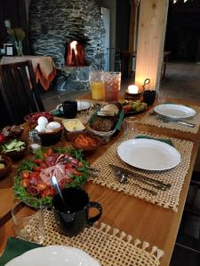 a table with plates of food and a fireplace at Maatilamatkailu Ali-Ketola in Kokemäki