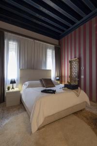 a bedroom with a large bed with red and white stripes at Corte Di Gabriela in Venice