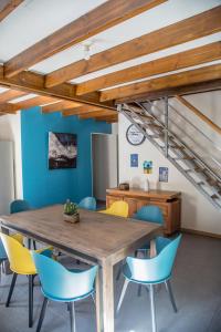 a dining room with a wooden table and blue chairs at Barbadine in La Plaine des Cafres