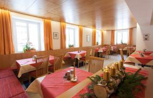 un restaurant avec des tables rouges, des chaises et des fenêtres dans l'établissement Pension Edelweiss, à Gargellen