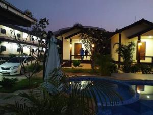 a house with a swimming pool in front of a house at SUNRAY Guesthouse สุนันท์บ้านพักริมคลอง in Uthai Thani
