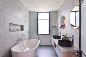 a bathroom with a white tub and two sinks at Villa Verde close to Finns Beach Club in Canggu +57 photos