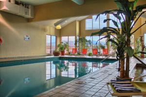ein Pool in einem Gebäude mit Stühlen und einer Pflanze in der Unterkunft Holiday Inn Hotel & Suites Osoyoos, an IHG Hotel in Osoyoos